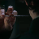 Reverend Mother Gaius Helen Mohiam's right hand holding up a poisoned needle to Paul Atreides' neck.